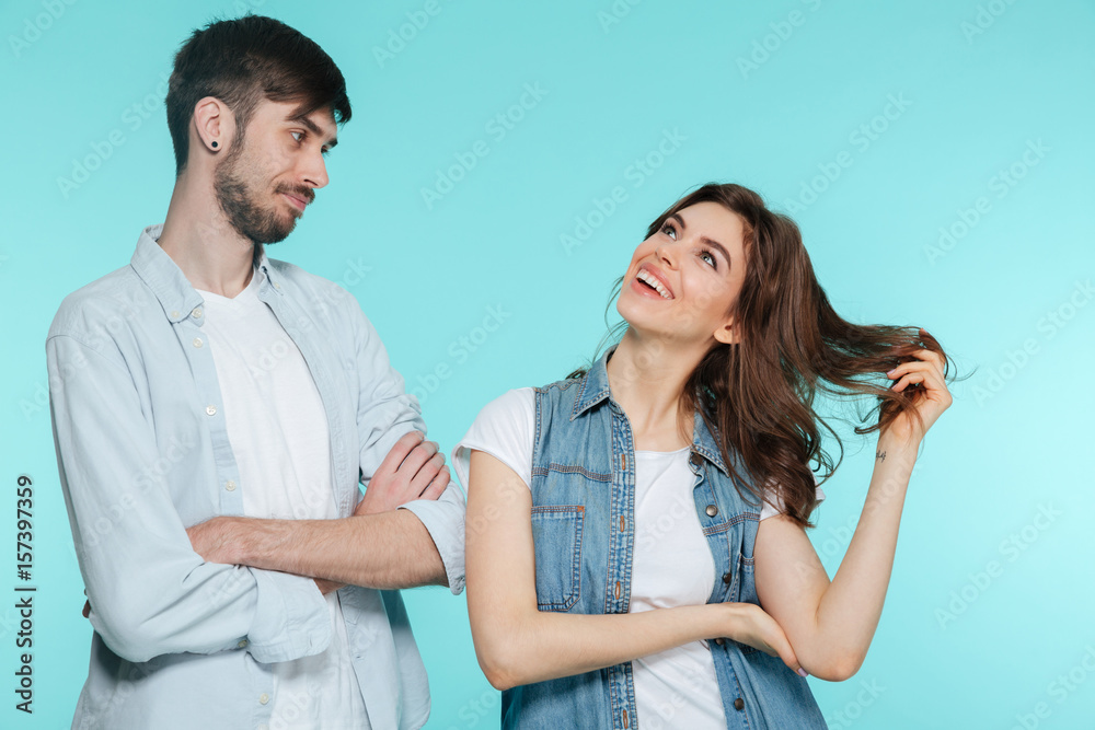 Concentrated young man standing with his happy sister Concentrated young man standing with his happy sister