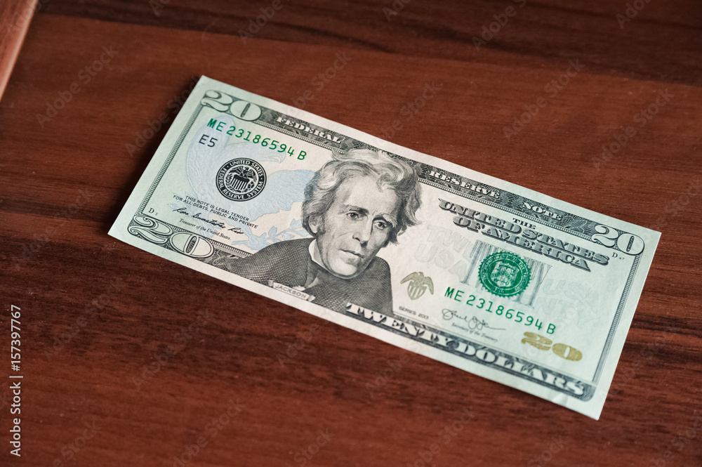 A lot of money on a wooden background. US dollars on one banknote, scattered, with a rubber band A lot of money on a wooden background. US dollars on one banknote, scattered, with a rubber band