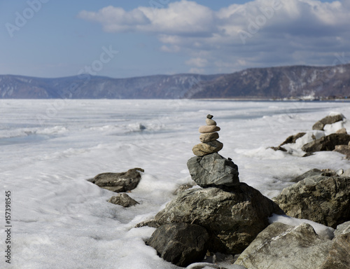 Stone tower on ice winter background. Baical landscape.