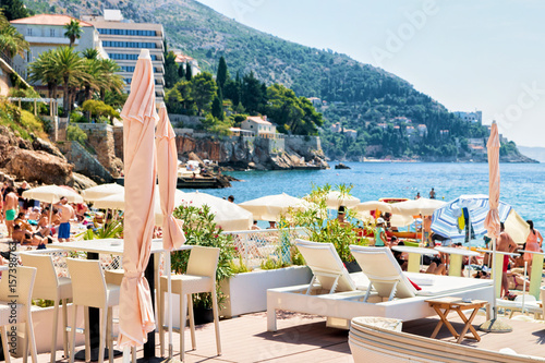 Fototapeta Naklejka Na Ścianę i Meble -  Shelters and deckchairs on beach at Adriatic Sea Dubrovnik