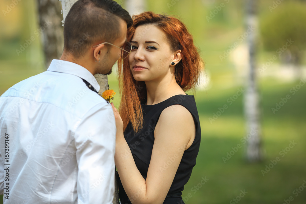 Couple in love. Handsome guy and pretty girl posing in the birch grove in the village.