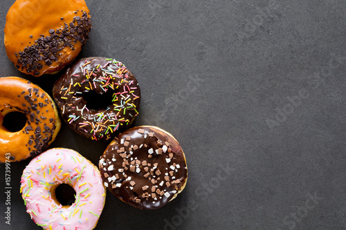 Canvas Print Glazed donuts on dark background. Table top view and copy space