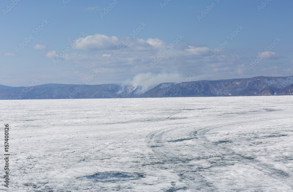 Baikal lake spring landscape view. Snow-covered surface of the ice lake. Winter. Baikal lake spring landscape view. Snow-covered surface of the ice lake. Winter.