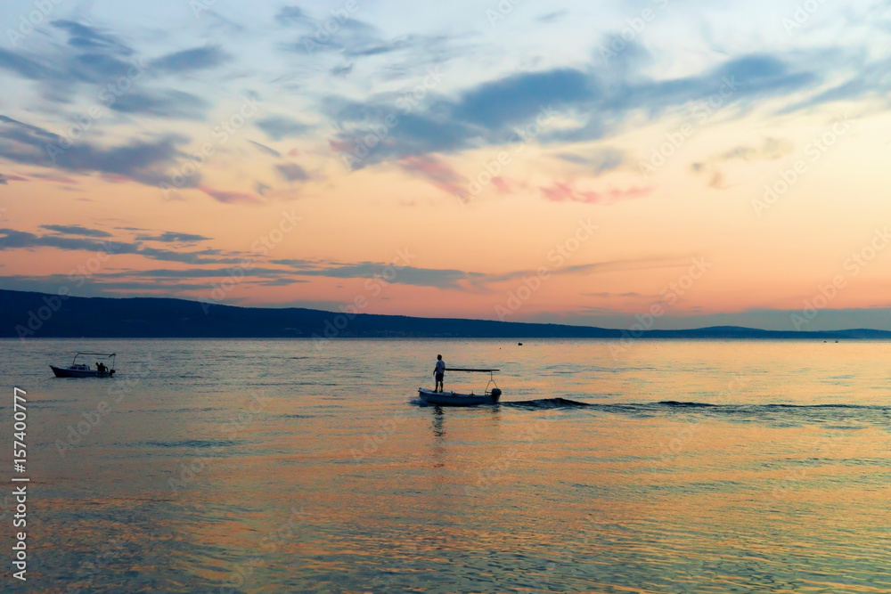 Person sailing in boat in Adriatic Sea Omis at sunset Person sailing in boat in Adriatic Sea Omis at sunset