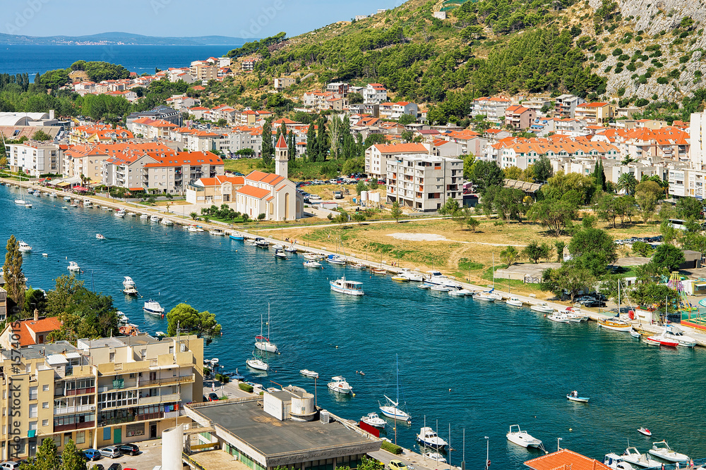Omis town between hills and Cetina River with boats