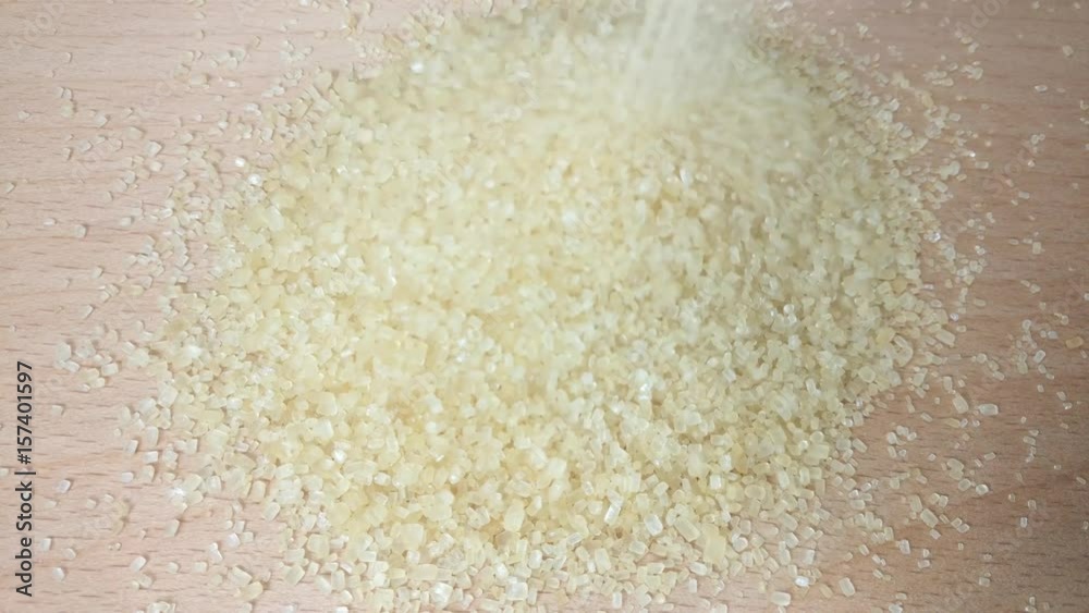 Great background of Brown Sugar crystals pouring onto wooden desk close up. Footage will work great for any videos dealing with cooking, medicine, healthy nutrition and much more. Great background of Brown Sugar crystals pouring onto wooden desk close up. Footage will work great for any videos dealing with cooking, medicine, healthy nutrition and much more.