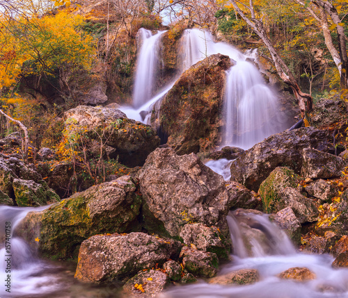 Autumn waterfall with stones in the forest