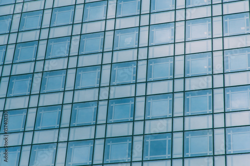Modern blue glass wall of skyscraper. Business building, office center. Abstract architecture, fragment of modern urban geometry. Background lines