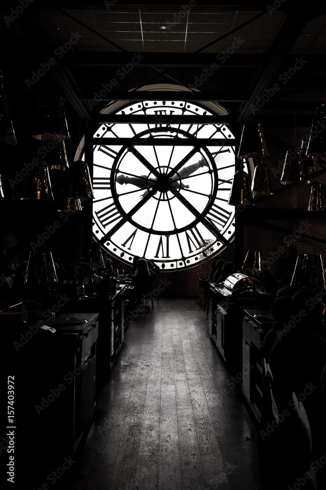 inside orsay museum and there is a big clock two people stand beside the clock