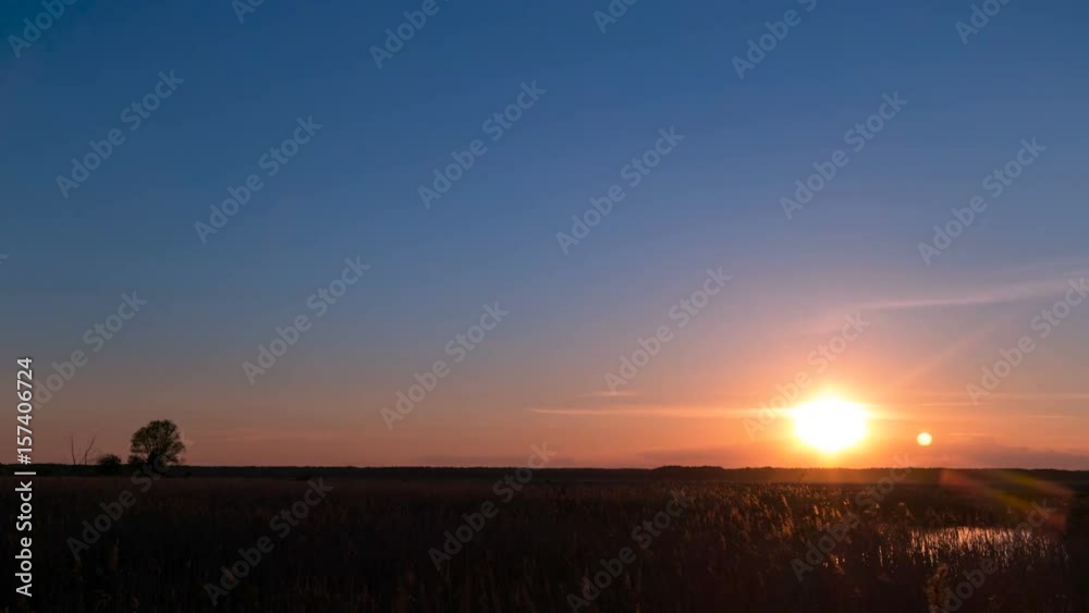 Timelapse. Sunset over the field and little pond.Lonley tree in the right side. Timelapse. Sunset over the field and little pond.Lonley tree in the right side.