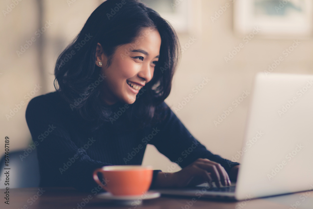 Asian woman working with her laptop and coffee on desk, Vintage color Asian woman working with her laptop and coffee on desk, Vintage color