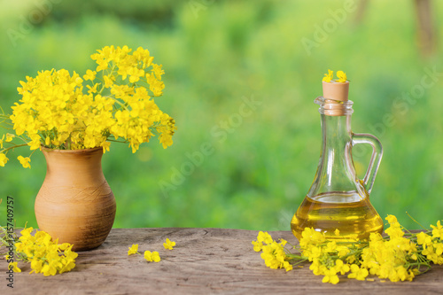 rapeseed oil  canola  and rape flowers on wooden table