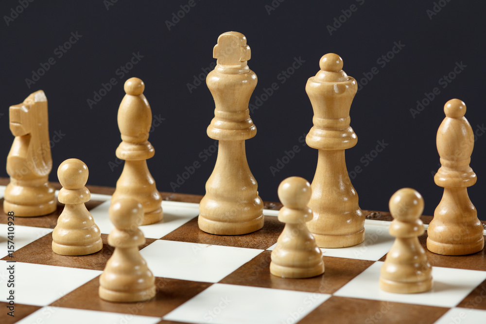 Chess board with wooden chess pieces Selective focus on white king. Chess board with wooden chess pieces Selective focus on white king.