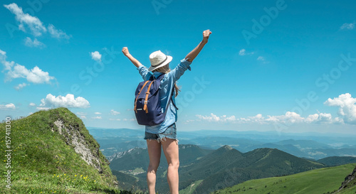 Woman hiking in mountains at sunny day time. © Andrii IURLOV