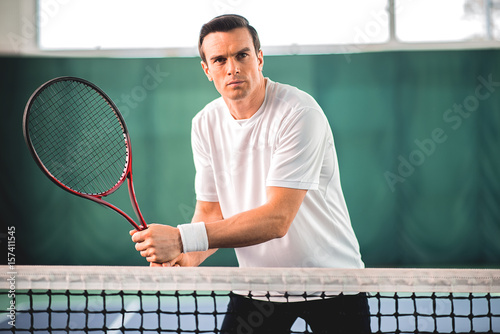 Serious sportsman playing tennis on court