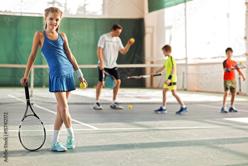 Satisfied female child enjoying tennis on court
