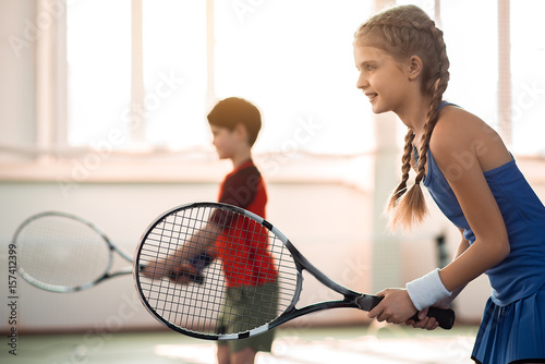 Excited children playing tennis on court © Yakobchuk Olena