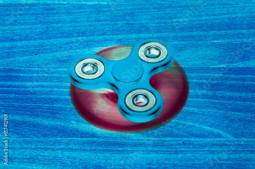 Fidget Spinner in fluorescent UV glowing isolated background for stress release during work