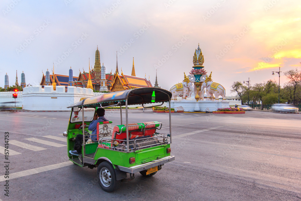 Fototapeta premium Tuk-tuk do samochodów osobowych na zwiedzanie wokół Wielkiego Pałacu w Bangkoku na tle zachodzącego słońca