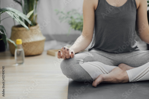 Cropped unrecognisable woman meditating in the Lotus pose (Padamasana).