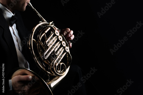 French horn instrument. Player hands playing horn music instrument photo