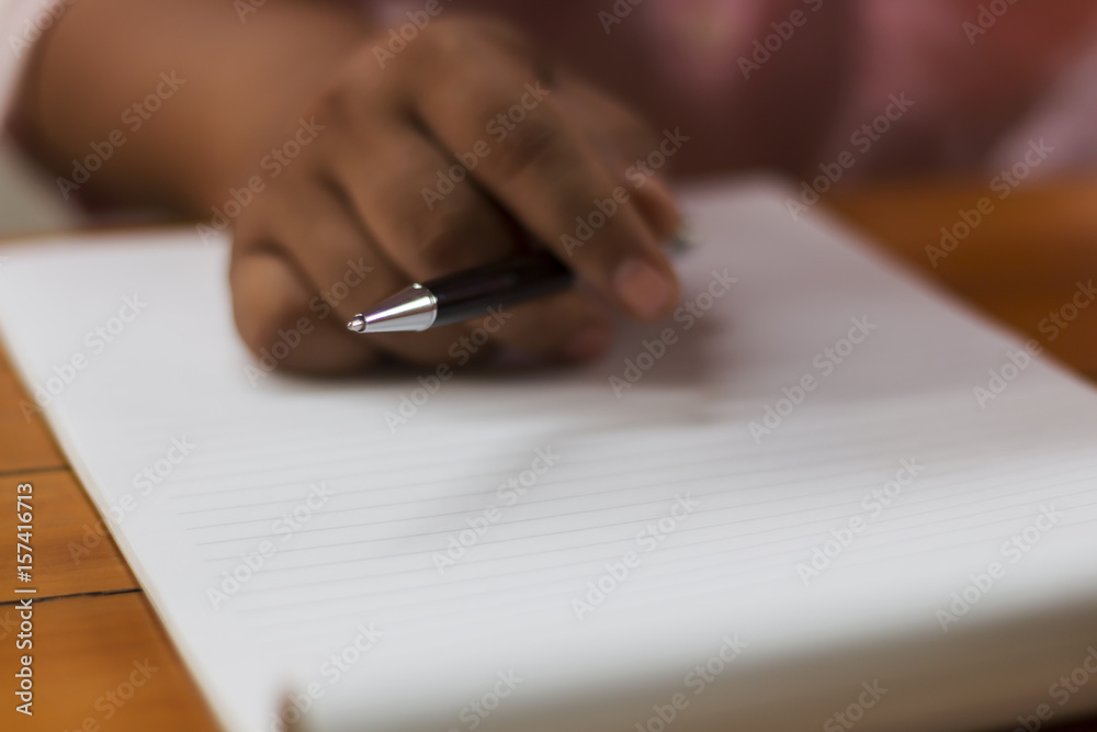 People are using pens to write something on paper. People are using pens to write something on paper.