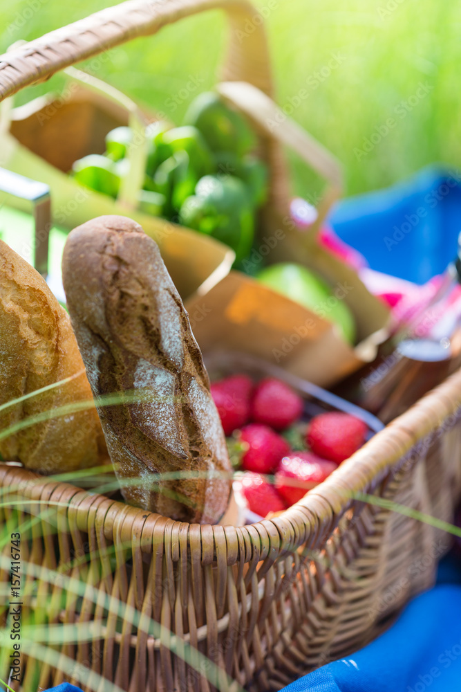 Summer basket for picnic  with wine, bread, fruits and snacks