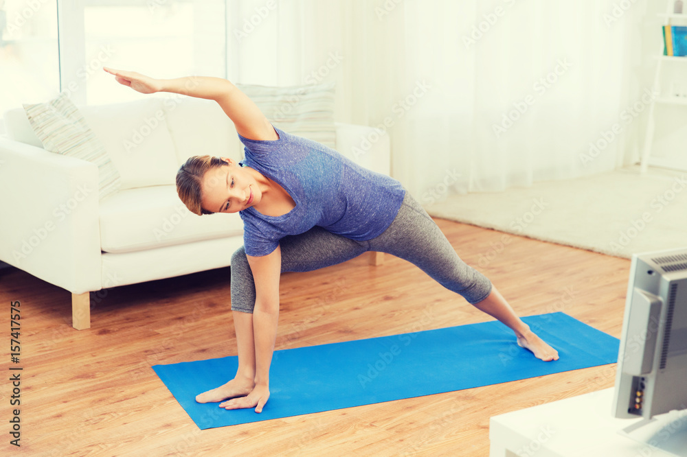 woman making yoga bikram triangle pose on mat woman making yoga bikram triangle pose on mat
