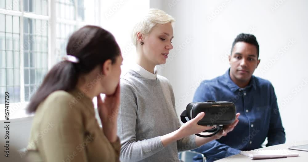 Designer presenting virtual reality headset in a meeting Designer presenting virtual reality headset in a meeting