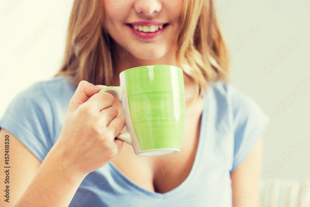 happy woman or teen girl drinking tea from cup