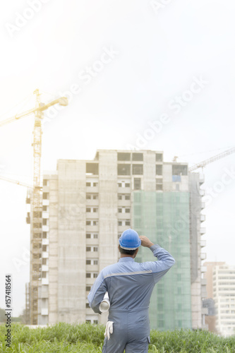 Wallpaper Mural worker or engineer holding drawing in hands on background of new apartment buildings and construction cranes on background.. Torontodigital.ca