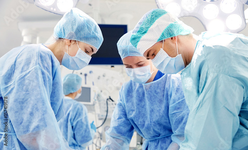 group of surgeons in operating room at hospital photo