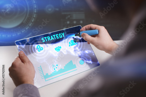 Business, Technology, Internet and network concept. Young businessman working on a virtual screen of the future and sees the inscription: Strategy
