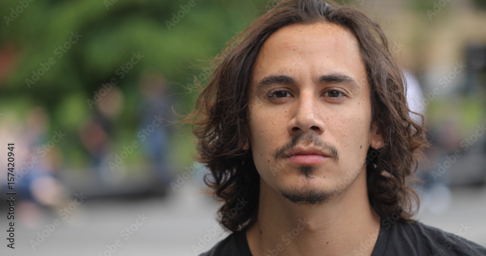 Young caucasian man in city park face portrait
