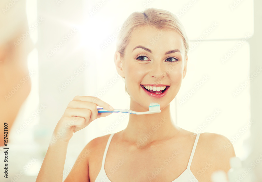 woman with toothbrush cleaning teeth at bathroom woman with toothbrush cleaning teeth at bathroom