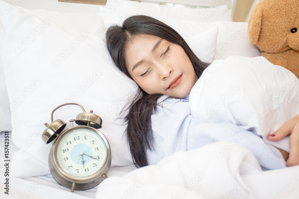 Young asian sleeping woman and alarm clock in bedroom at home, woman sleeping concept, 20s year old. Young asian sleeping woman and alarm clock in bedroom at home, woman sleeping concept, 20s year old.