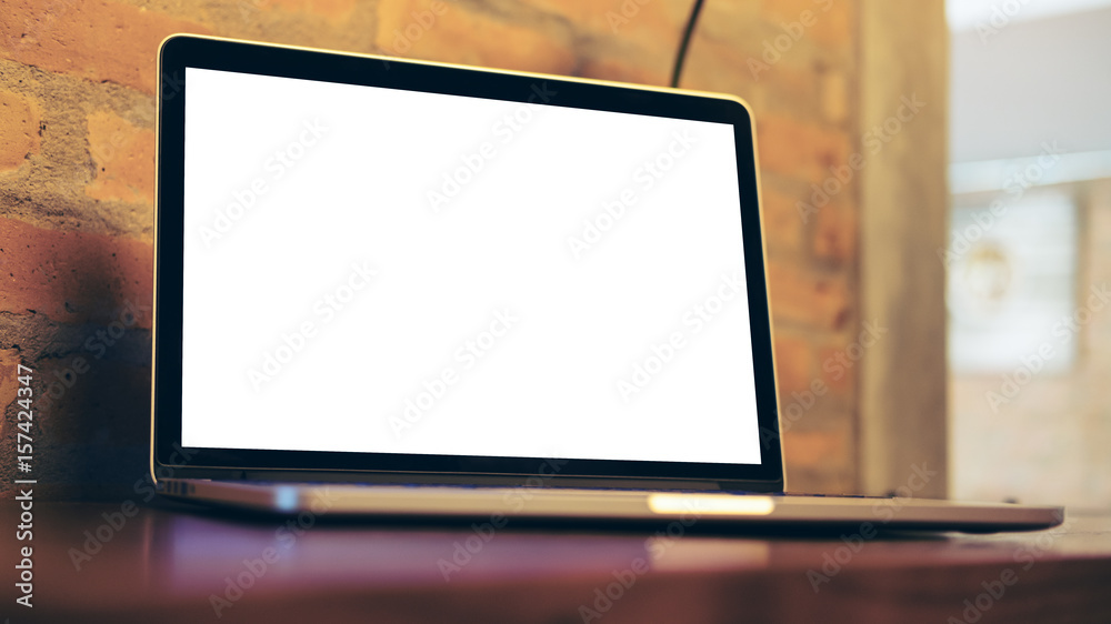 Mockup image of laptop with blank white screen on wooden table in wooden modern cafe Mockup image of laptop with blank white screen on wooden table in wooden modern cafe