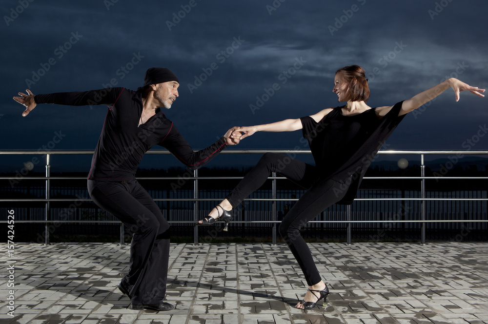 Senior couple ballroom dancing on dark sunset Senior couple ballroom dancing on dark sunset