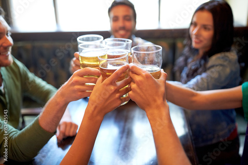 happy friends drinking beer at bar or pub