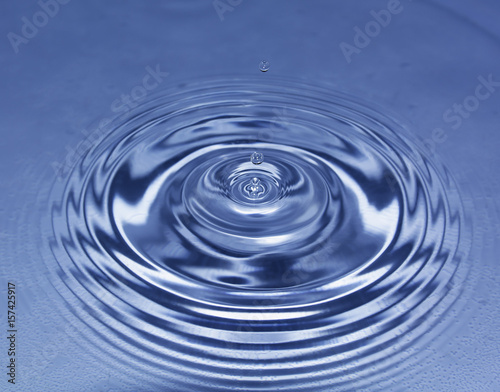 Blue water drop falling down. Blue water splash.