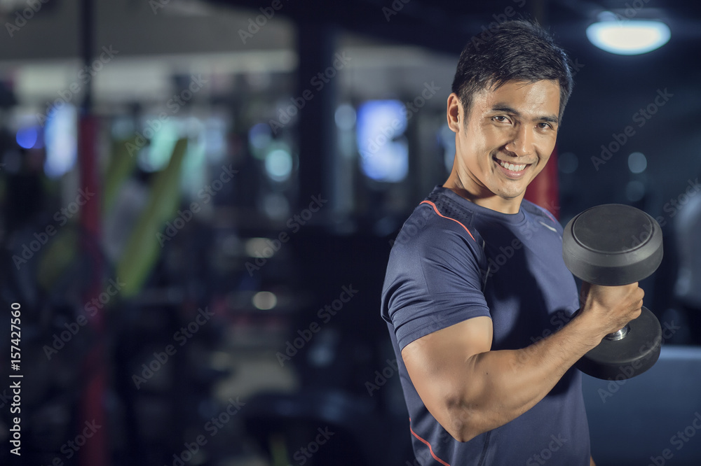 Muscular builder man training his body with dumbbell Muscular builder man training his body with dumbbell