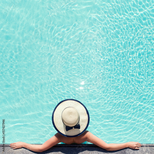 Beautiful woman sunbathing by the pool top view. Summer background for poster. Mock up for design.