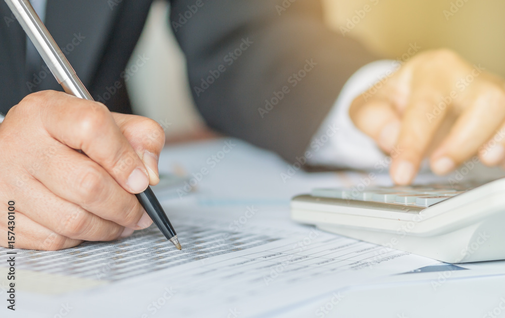 Hand calculator and holding pencil for analyzing financial data and counting on document chart, business concept. Hand calculator and holding pencil for analyzing financial data and counting on document chart, business concept.