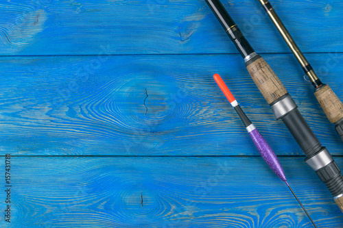 Fototapeta Naklejka Na Ścianę i Meble -  Fishing tackle - fishing rod fishing float and lures on beautiful blue wooden background
