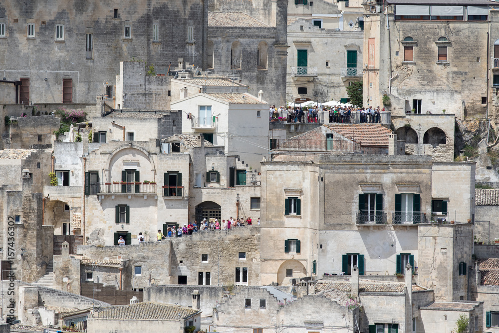 Matera, Italy - May 20 2017: Panoramic view of the city from the belvedere square with tourists visiting the city