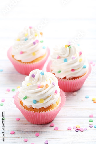 Платно Tasty cupcakes on a white wooden table