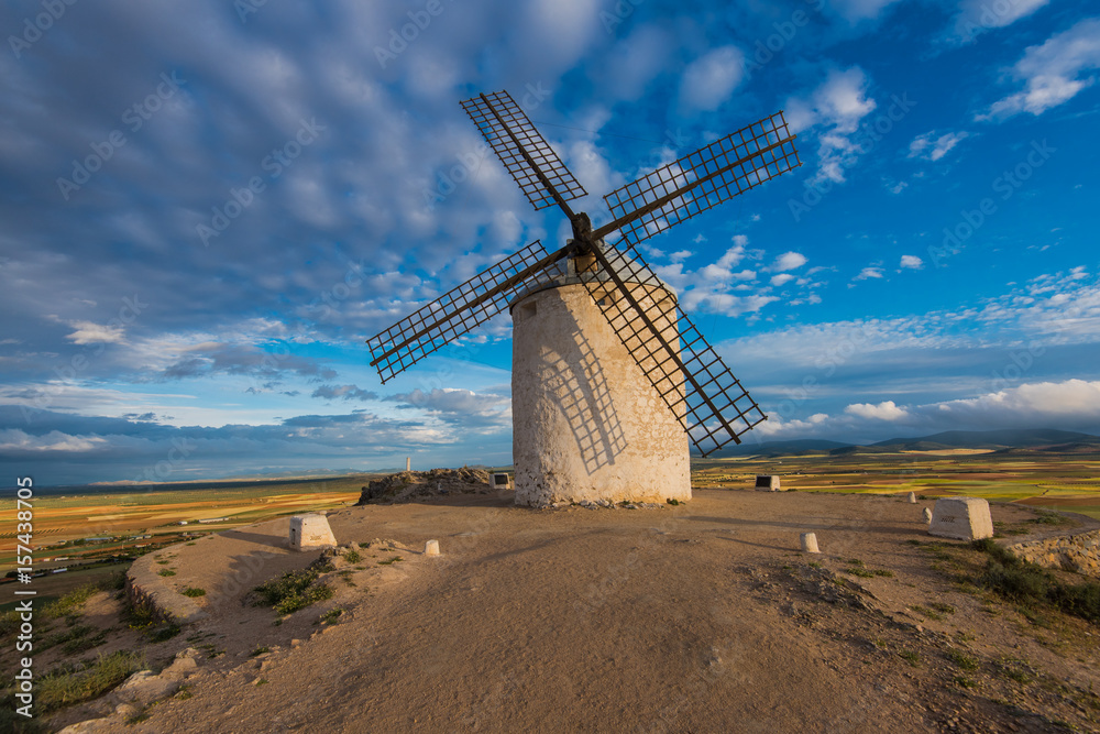 Ancient windmill on hill top with rural landscape