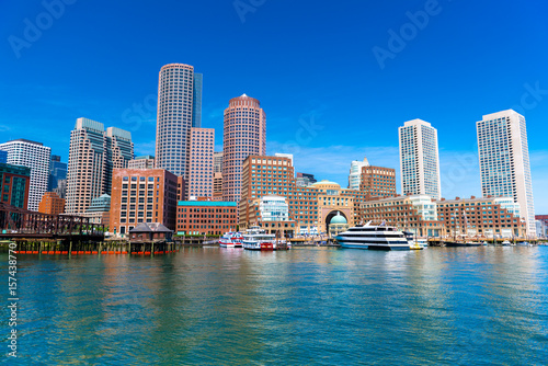 Boston cityscape reflected in water, skyscrapers and office buildings in downtown against the clear blue sky, view from Boston harbor, USA © Travellaggio