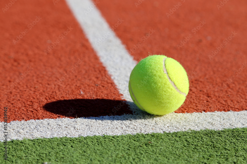 Gelber Tennisball liegt auf weißer Linie, Symbolbild Tennis