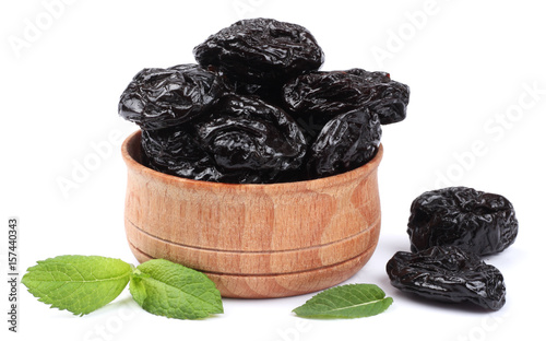 Dried plums - prunes in wooden bowl isolated on white background